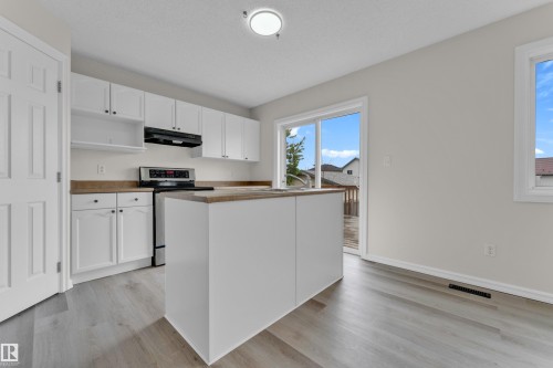 Kitchen with white cabinetry, stainless steel range, and a central island - 2912 31 Street Nw, Edmonton, AB 
