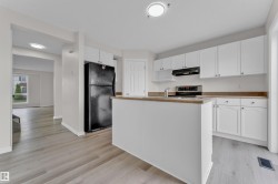Kitchen featuring white cabinetry, light wood-finish countertops, stainless-steel range, and a central island - 