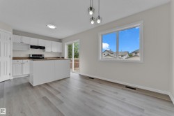 Kitchen with white cabinetry, stainless steel appliances, wood-finish countertops, and a central island - 