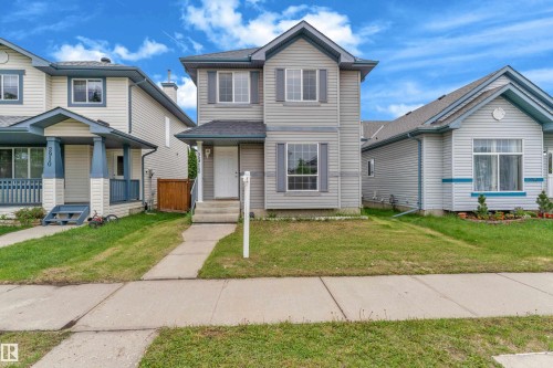 Two-story residence with siding exterior, multi-pane windows, and a paved walkway leading to the front entry - 2912 31 Street Nw, Edmonton, AB 