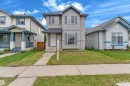 Two-story residence with siding exterior, multi-pane windows, and a paved walkway leading to the front entry - 2912 31 Street Nw, Edmonton, AB 