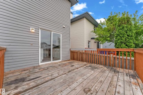 Expansive wooden deck with coordinating wood railing, adjacent to gray horizontal siding - 2912 31 Street Nw, Edmonton, AB 