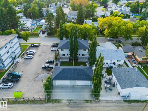 Duplex property with a detached two-car garage, mature landscaping, and a paved parking area - 53/55 Michigan Street, Devon, AB 