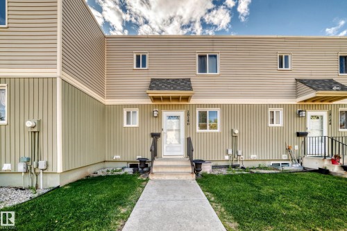 Two-story townhome with tan horizontal siding and vertical paneling - 18146 81 Avenue Nw, Edmonton, AB 