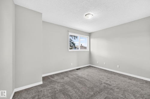 Neutral gray walls, dark gray carpeting, white trim, and a white window frame with a single pane - 18146 81 Avenue Nw, Edmonton, AB 