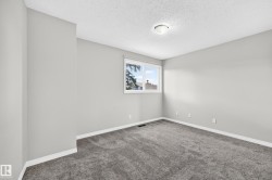 Neutral gray walls, dark gray carpeting, white trim, and a white window frame with a single pane - 