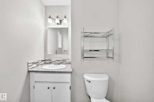 Vanity with an integrated sink, mosaic tile backsplash, and overhead light fixture - 18146 81 Avenue Nw, Edmonton, AB 