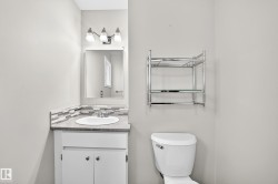 Vanity with an integrated sink, mosaic tile backsplash, and overhead light fixture - 