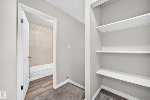 Built-in shelving, neutral wall paint, white trim, and carpeted flooring - 18146 81 Avenue Nw, Edmonton, AB 