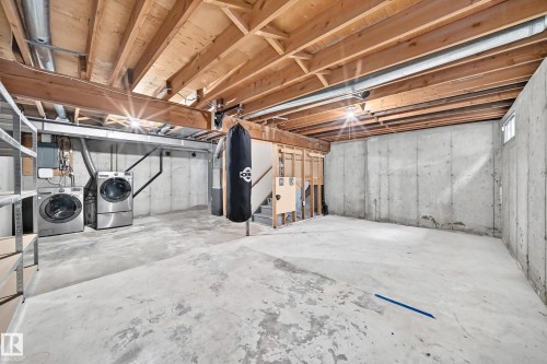 Unfinished basement with exposed ceiling joists, concrete flooring, concrete walls, and a small basement window - 18146 81 Avenue Nw, Edmonton, AB 