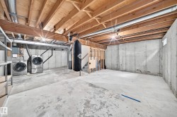 Unfinished basement with exposed ceiling joists, concrete flooring, concrete walls, and a small basement window - 