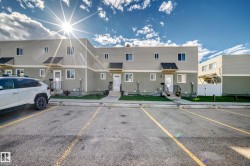 Two-story townhome with light siding and dark trim - 