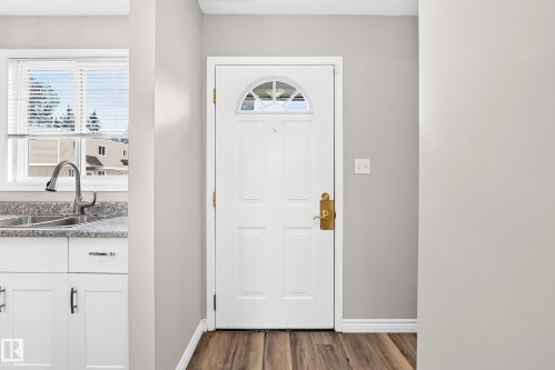 Entry door with arched window detail and brass hardware - 18146 81 Avenue Nw, Edmonton, AB 