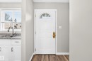 Entry door with arched window detail and brass hardware - 18146 81 Avenue Nw, Edmonton, AB 