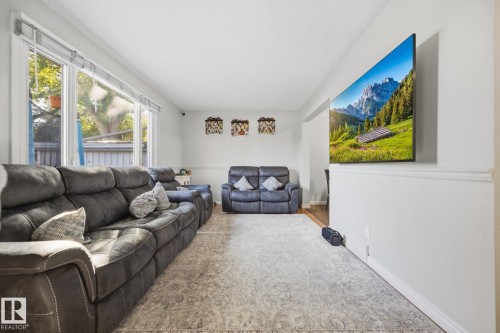 Large window with multiple panes, white walls, and wood-finish flooring - #2 14120 80 St Nw, Edmonton, AB 