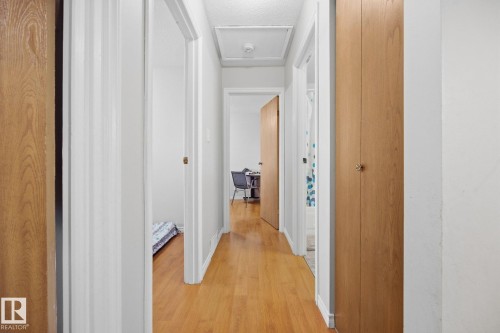 Hardwood-style flooring throughout a well-lit hallway - #2 14120 80 St Nw, Edmonton, AB 
