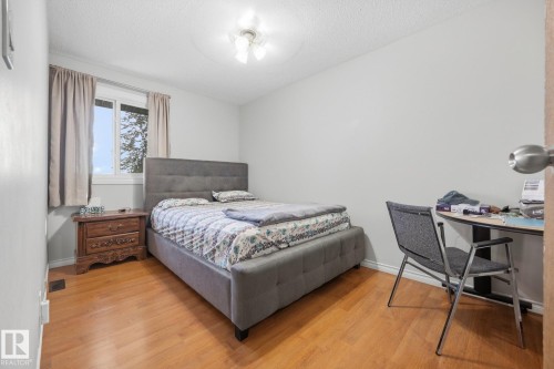 Wood-finish flooring with white baseboards, a window with white trim, and a ceiling-mounted light fixture - #2 14120 80 St Nw, Edmonton, AB 