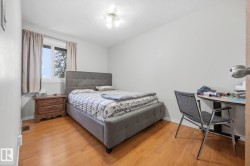 Wood-finish flooring with white baseboards, a window with white trim, and a ceiling-mounted light fixture - 