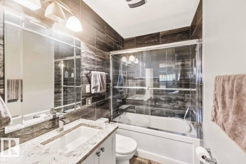 White vanity with a stone countertop and integrated rectangular sink - 13427 83 Street Nw, Edmonton, AB 