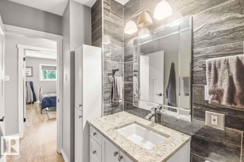 Bathroom vanity with a granite countertop, undermount sink, and chrome faucet - 13427 83 Street Nw, Edmonton, AB 