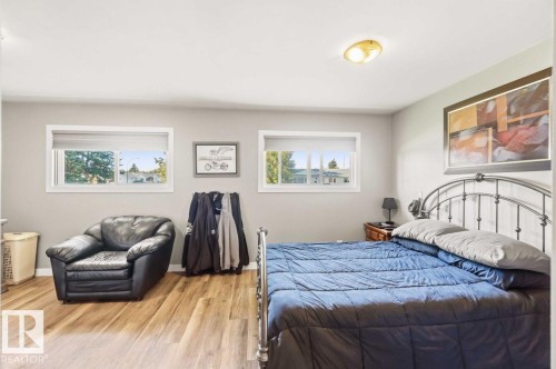 Wood-finish flooring, two windows with white trim, light gray painted walls, and a ceiling-mounted light fixture - 13427 83 Street Nw, Edmonton, AB 