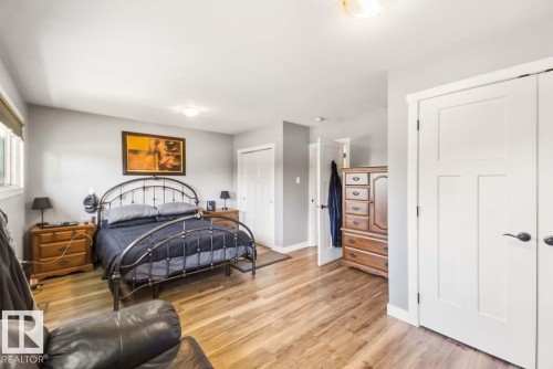 Wood-finish flooring, white trim, and light gray walls - 13427 83 Street Nw, Edmonton, AB 