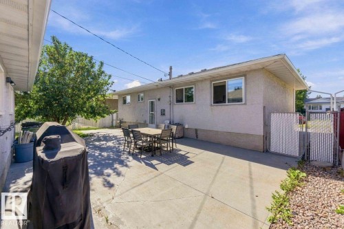 Expansive concrete patio with direct exterior access, stucco siding, and a fenced perimeter - 13427 83 Street Nw, Edmonton, AB 