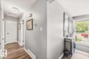 Wood-finish flooring throughout, complemented by white trim and doors, and a ceiling-mounted light fixture - 13427 83 Street Nw, Edmonton, AB 