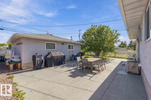 Expansive concrete patio with ample outdoor space, mature tree, and stucco exterior - 13427 83 Street Nw, Edmonton, AB 