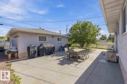 Expansive concrete patio with ample outdoor space, mature tree, and stucco exterior - 