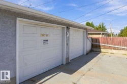 Two white panel garage doors with stucco exterior - 