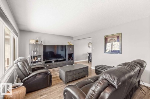 Wood-finish flooring throughout, light gray wall finishes, and a dedicated media wall - 13427 83 Street Nw, Edmonton, AB 