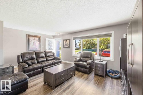 Recessed lighting, wood-finish flooring, light gray wall paint, white trim, and a prominent window - 13427 83 Street Nw, Edmonton, AB 