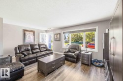 Recessed lighting, wood-finish flooring, light gray wall paint, white trim, and a prominent window - 