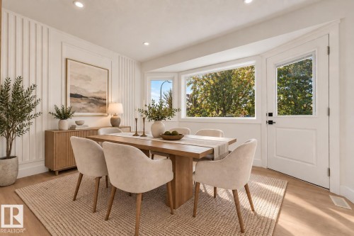 Recessed lighting, wood-finish flooring, bay window, white paneled accent wall, and a side-lite door - 3320 43 Street Nw, Edmonton, AB 