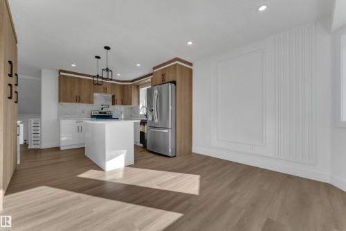 Kitchen featuring stainless steel appliances, a white island, and wood-finish cabinetry - 3320 43 Street Nw, Edmonton, AB 