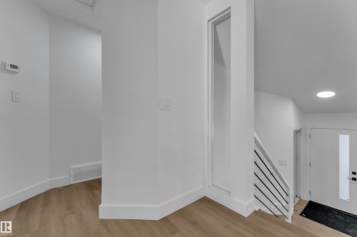 Wood-finish flooring, white walls, and a modern staircase with horizontal railings - 3320 43 Street Nw, Edmonton, AB 