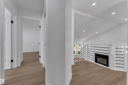 Vaulted ceilings with recessed lighting, wood-finish flooring, and a modern horizontal railing system - 3320 43 Street Nw, Edmonton, AB 