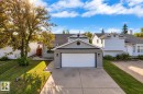 Contemporary exterior with gray siding, attached garage, and a concrete driveway - 3320 43 Street Nw, Edmonton, AB 