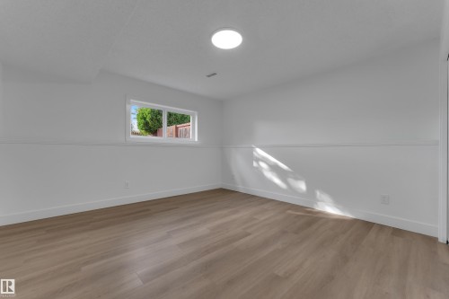 Recessed lighting, wood-finish flooring, white walls, and a window providing natural light - 3320 43 Street Nw, Edmonton, AB 