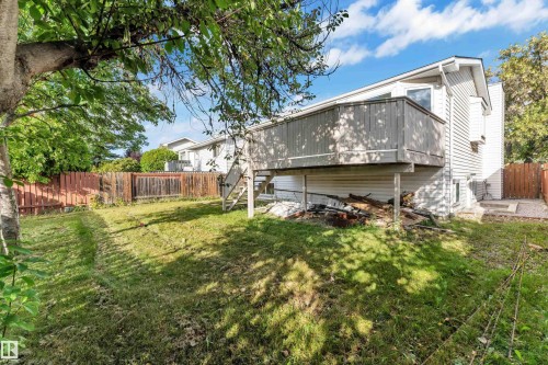 Expansive backyard featuring a wood deck with railings, privacy fencing, and mature trees - 3320 43 Street Nw, Edmonton, AB 