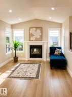 Vaulted ceiling, recessed lighting, wood-finish flooring, fireplace with white mantel, and multiple windows - 