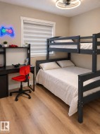 Wood-finish flooring, neutral wall tones, window with horizontal blinds, built-in ceiling light fixture - 