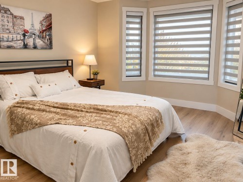 Bay window with custom window treatments, wood-finish flooring, and a contemporary headboard - 3830 22 Street Nw, Edmonton, AB 