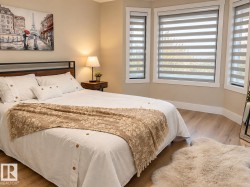 Bay window with custom window treatments, wood-finish flooring, and a contemporary headboard - 