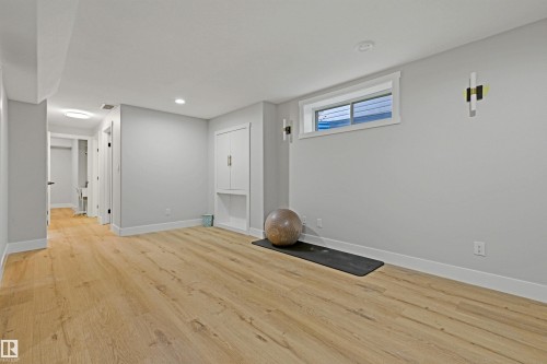 Light wood-finish flooring, recessed lighting, built-in cabinetry, and wall-mounted sconces - 3830 22 Street Nw, Edmonton, AB 