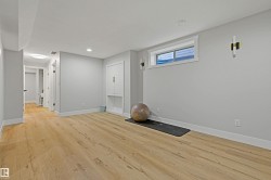Light wood-finish flooring, recessed lighting, built-in cabinetry, and wall-mounted sconces - 