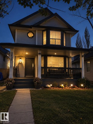 Two-story residence featuring light-toned horizontal siding with dark trim, a covered front porch with white columns, and a prominent bay window - 3830 22 Street Nw, Edmonton, AB 
