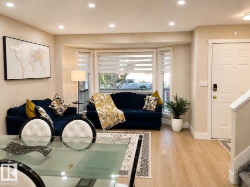 Recessed ceiling lighting, bay window, wood-finish flooring, white paneled entry door, and staircase with carpeted treads - 3830 22 Street Nw, Edmonton, AB 