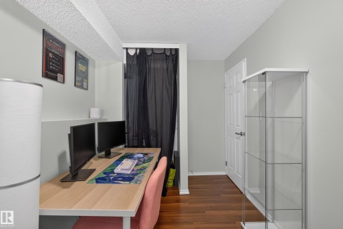 Wood-finish flooring, white paneled door, and textured ceiling - 333 Kirkpatrick Crescent Nw, Edmonton, AB 